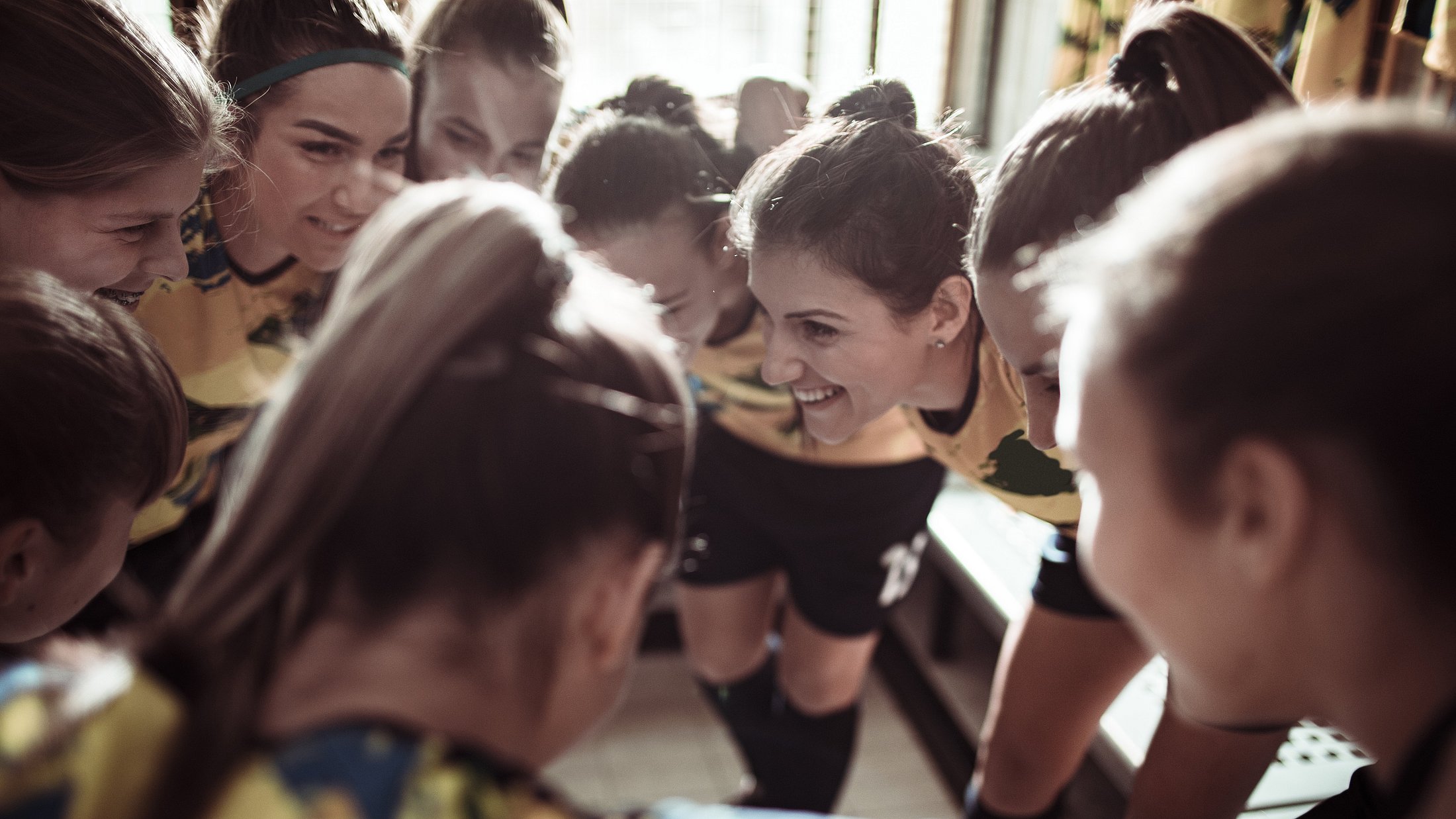 eine Frauenmannschaft steht im Kreis zusammen und motivieren sich 