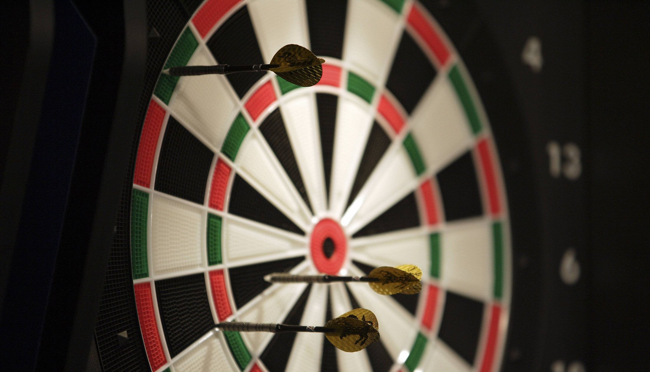 Nahaufnahme. mehrere Pfeile stecken in einer Dartsscheibe