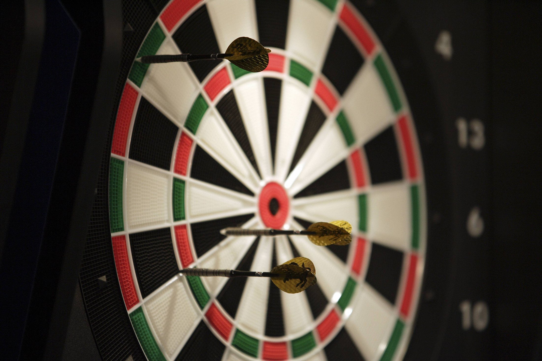 Nahaufnahme. mehrere Pfeile stecken in einer Dartsscheibe